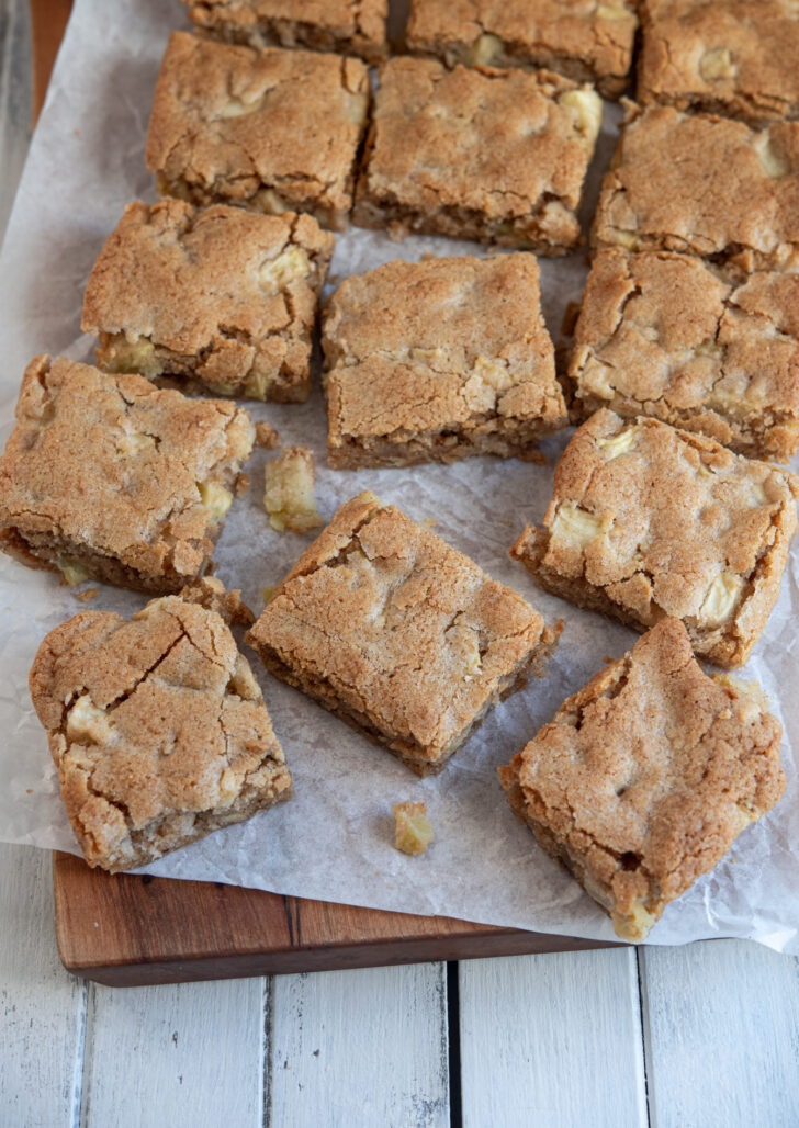 Apple brownies (apple blondies) are sliced into bars on a cutting board