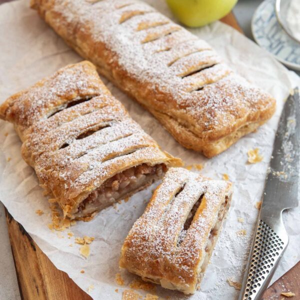 Apple strudel dusted with powdered sugar and sliced.