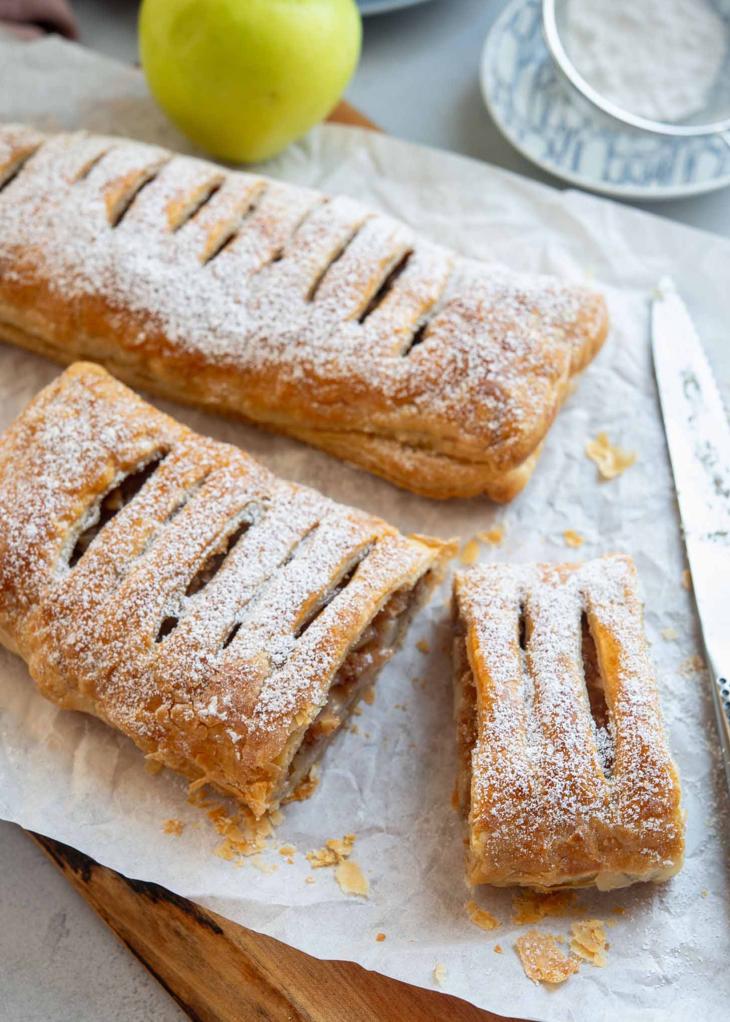 Puff pastry apple strudel dusted with powdered sugar and sliced.
