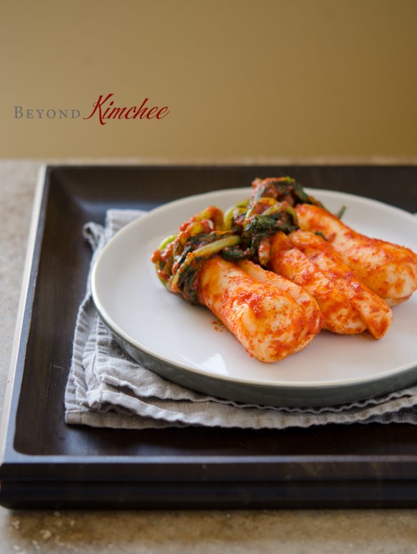 Ponytail radish kimchi is bundled on a white plate.