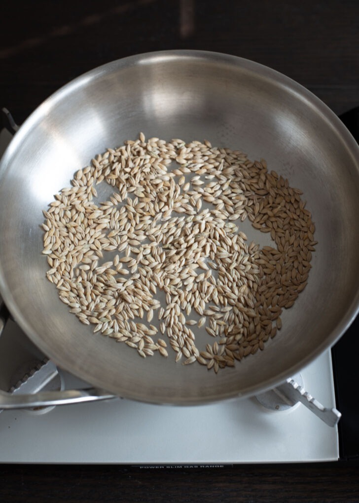 Whole barley grains in a skillet for barley tea (boricha).