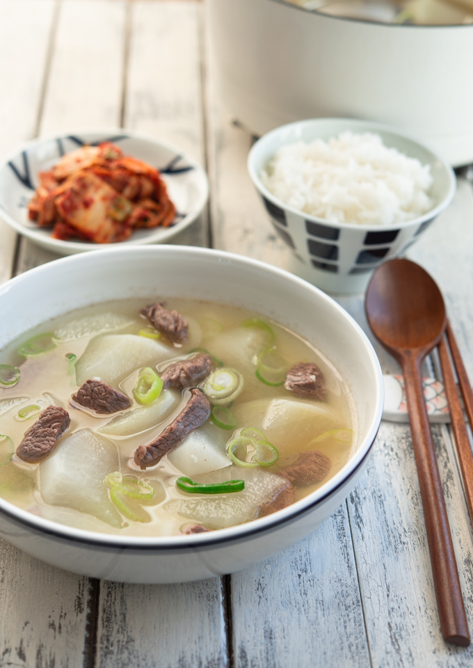 Korean beef radish soup is served with rice and kimchi.