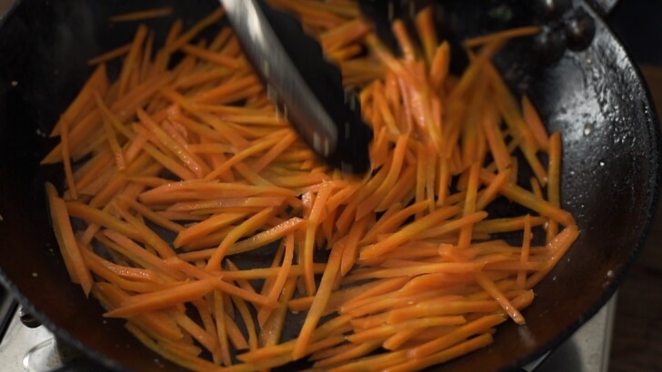 Shredded carrots cooked in a skillet.