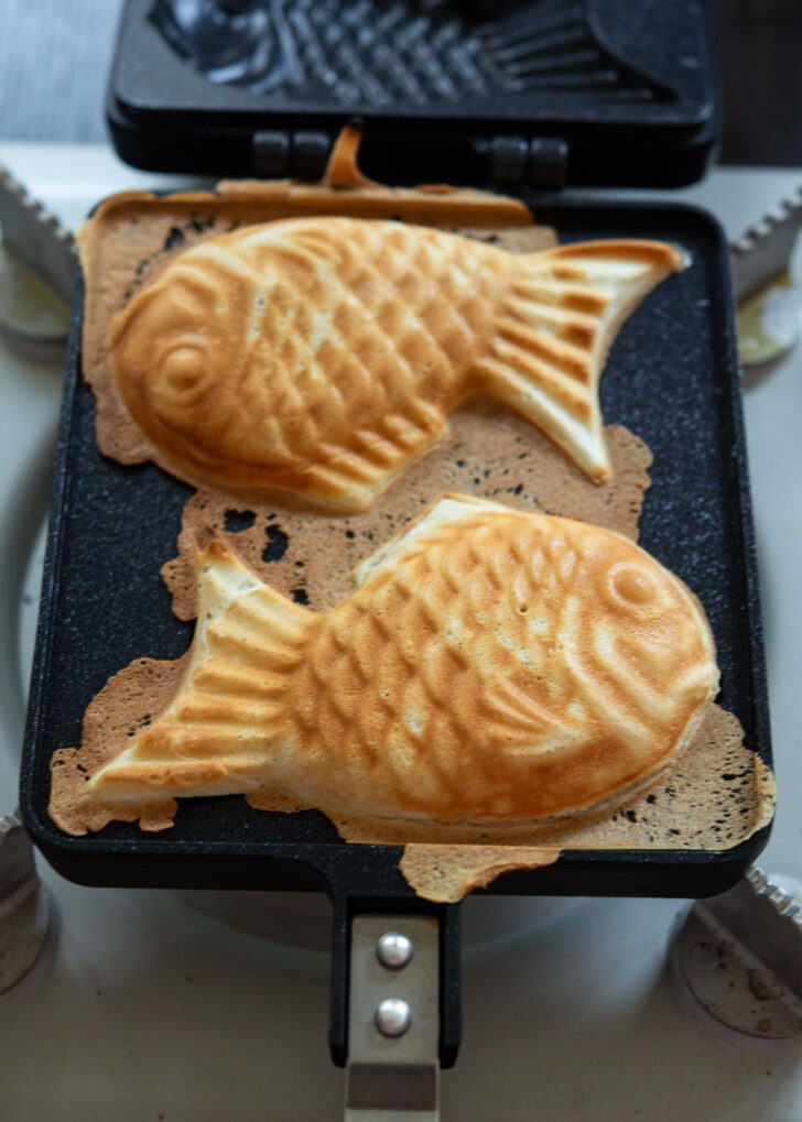 Two pieces of bungeoppang baked in a fish shaped mold.