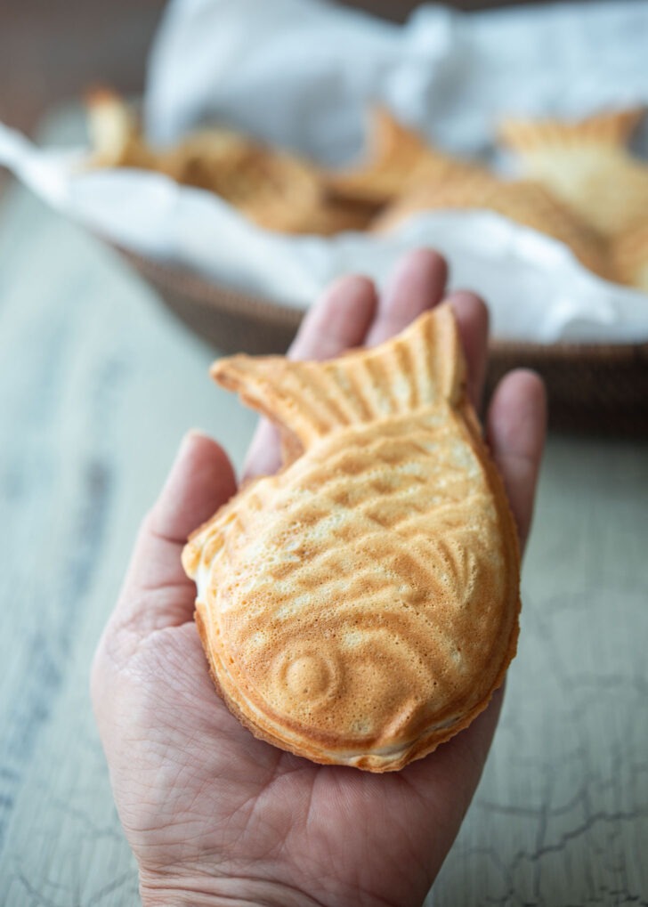A hand holding a bungeoppang fish pastry.
