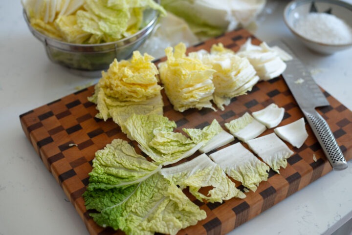 cabbage is cut to pieces to make kimchi