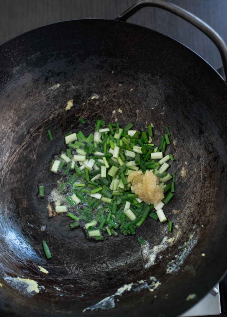 Green onion and garlic is stir-frying in a wok to be aromatic.