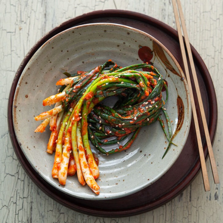 A bundle of Pa Kimchi is placed on a serving dish with a pair of chopsticks.