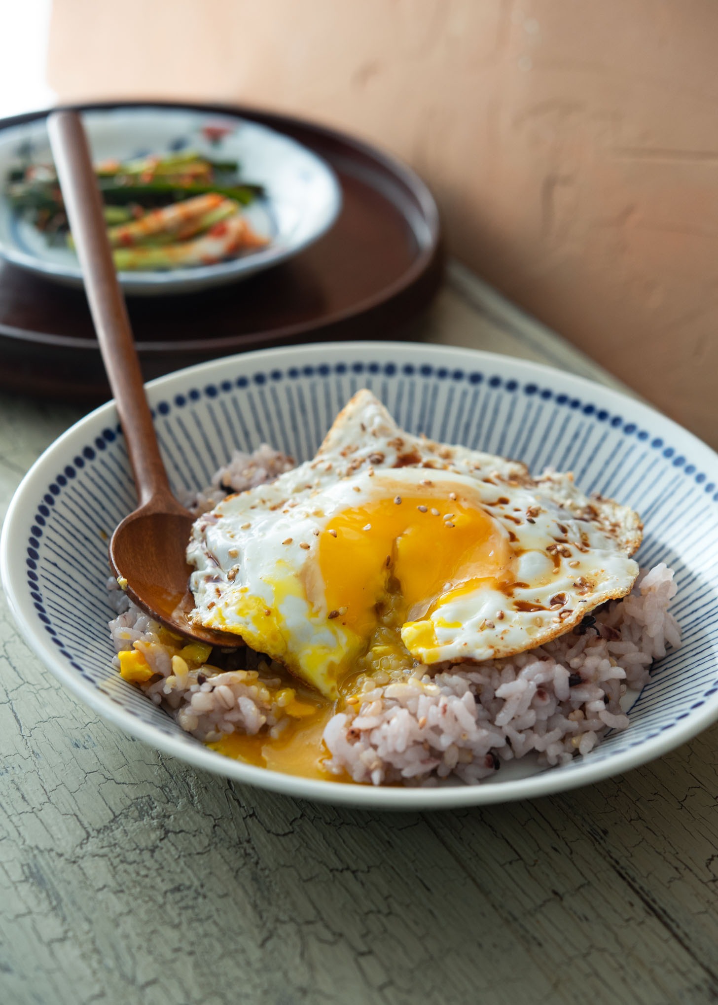 Golden egg yolk running down from Korean gyeran bap, rice with fried egg.
