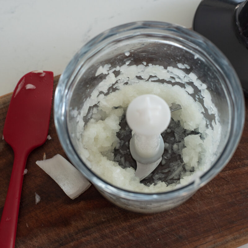 Onion is finely processed in a mini food processor.
