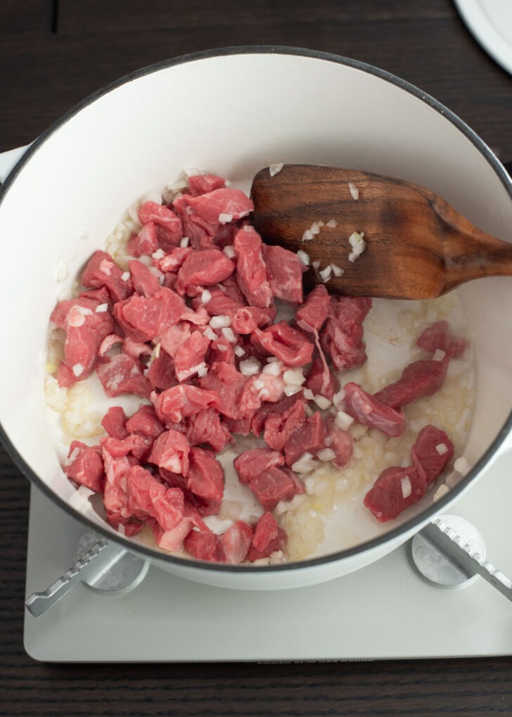 Beef and onion cooking in a pot.