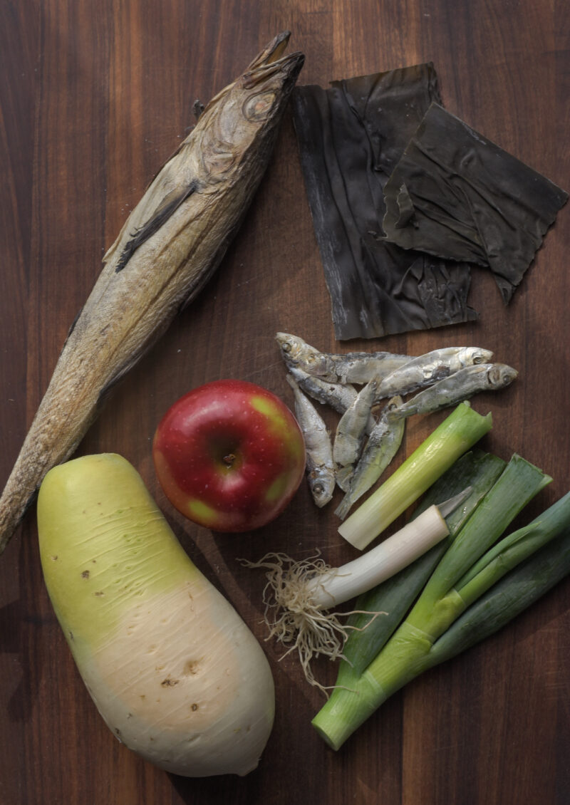 Dried whole fish, other dried seafood, apple and radish are gathered and displayed.