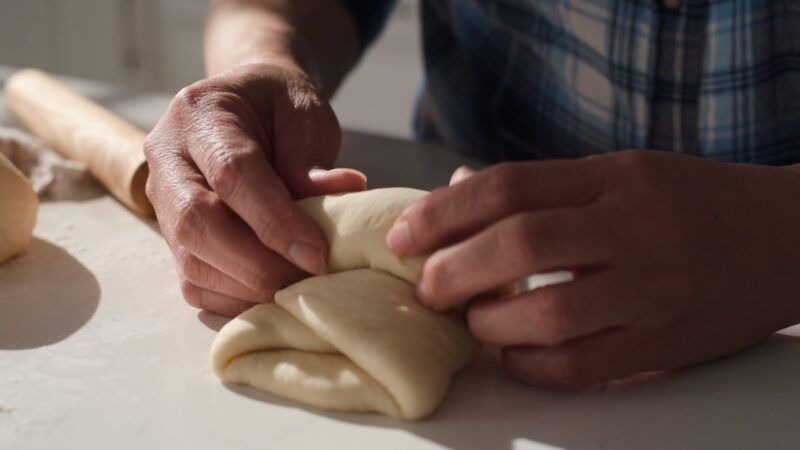 Pinching milk bread dough tightly.