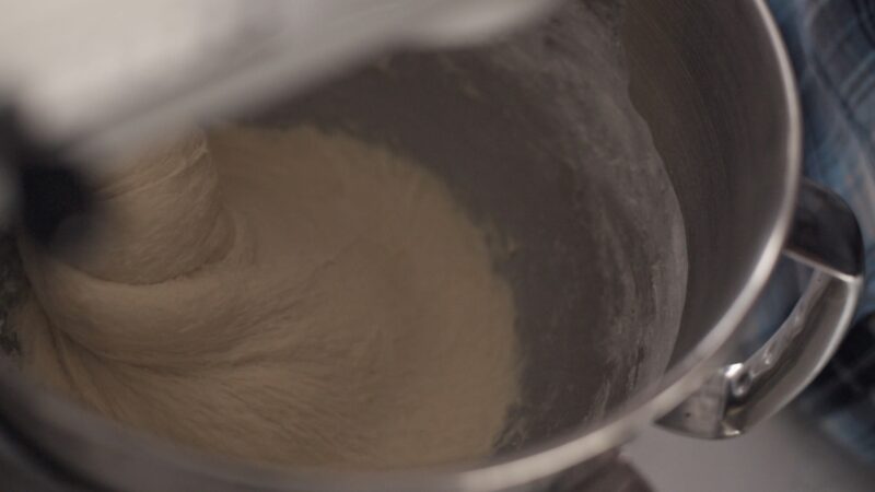 Milk bread dough being kneaded in a stand mixer.
