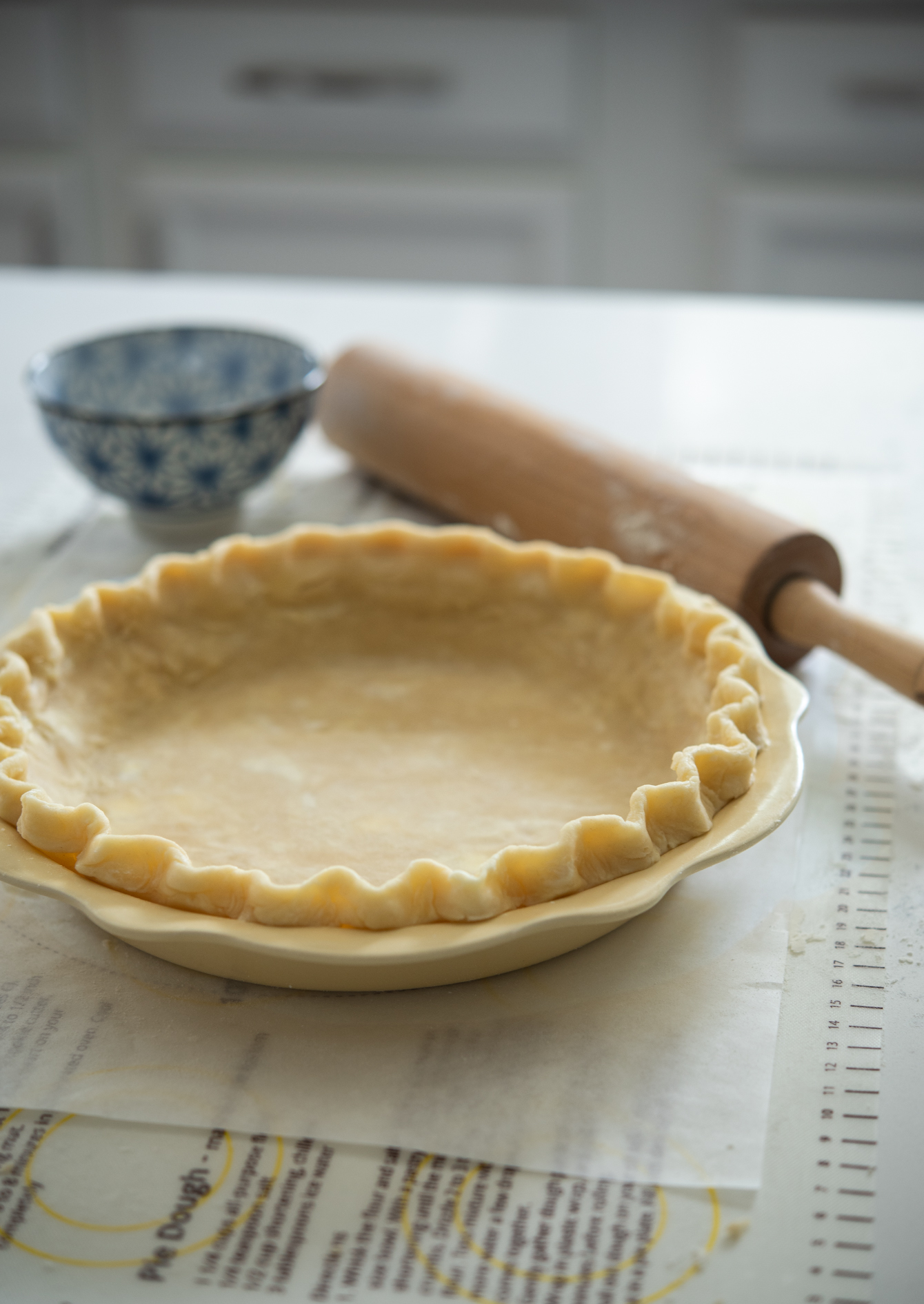 Light and flaky lard and butter pie crust is rolled and fluted in a pie pan.