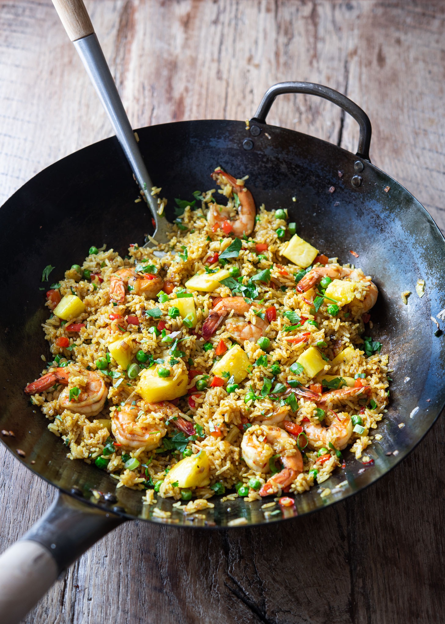 Thai style pineapple fried rice is prepared in a large wok.