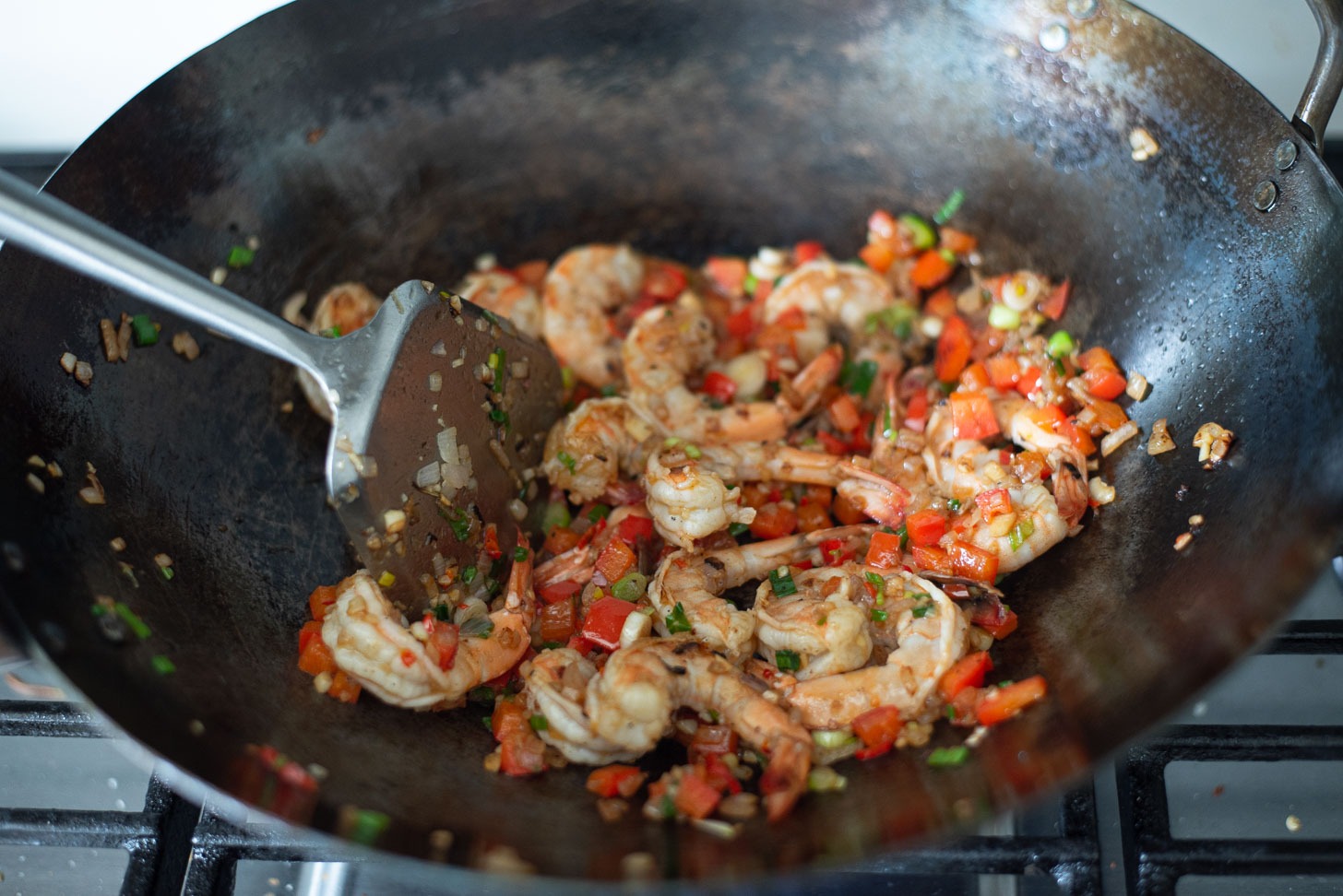 Chili and shrimp are added to the vegetables in a wok to make Thai pineapple fried rice.