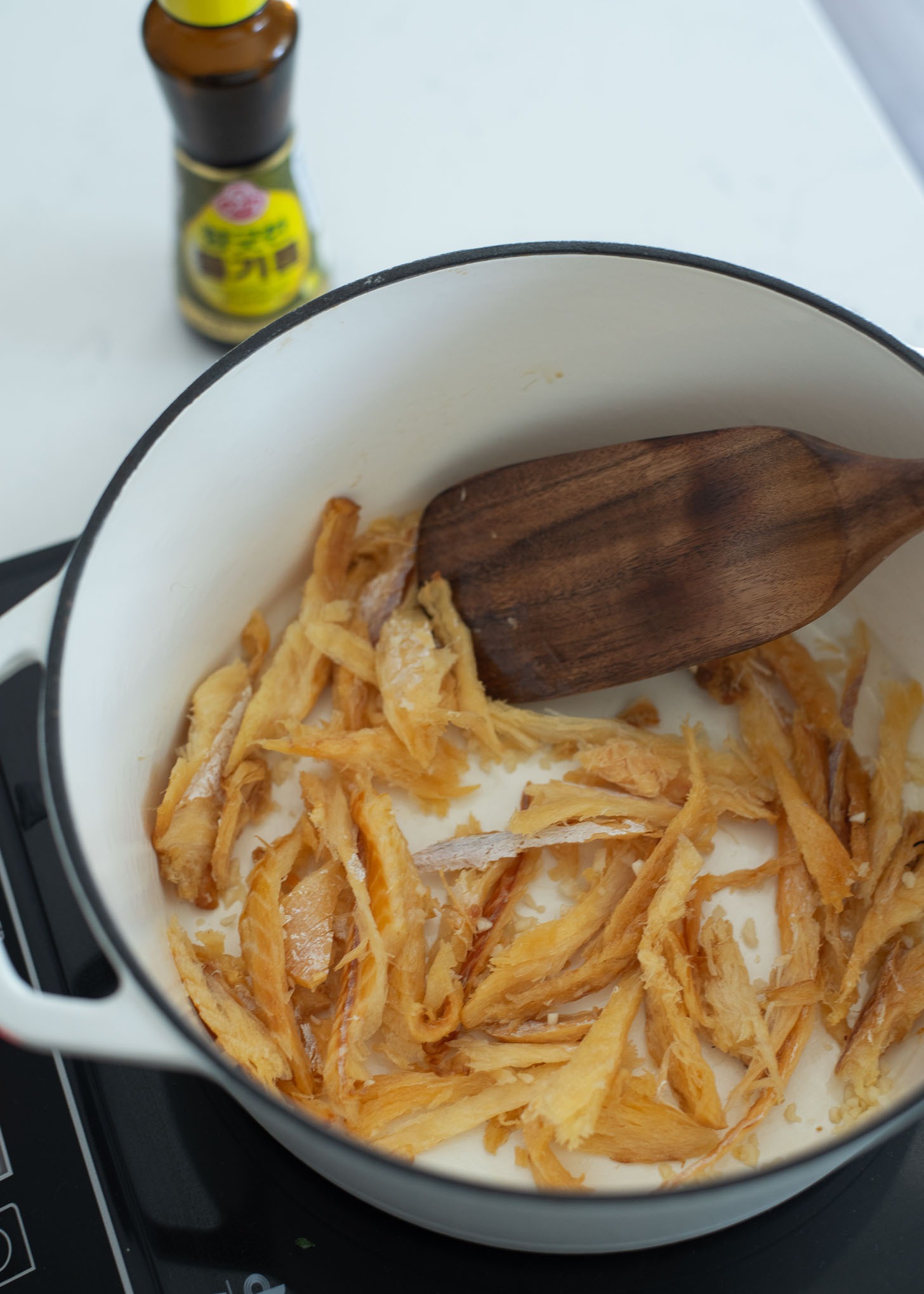 Cook shredded pollock fish in oil