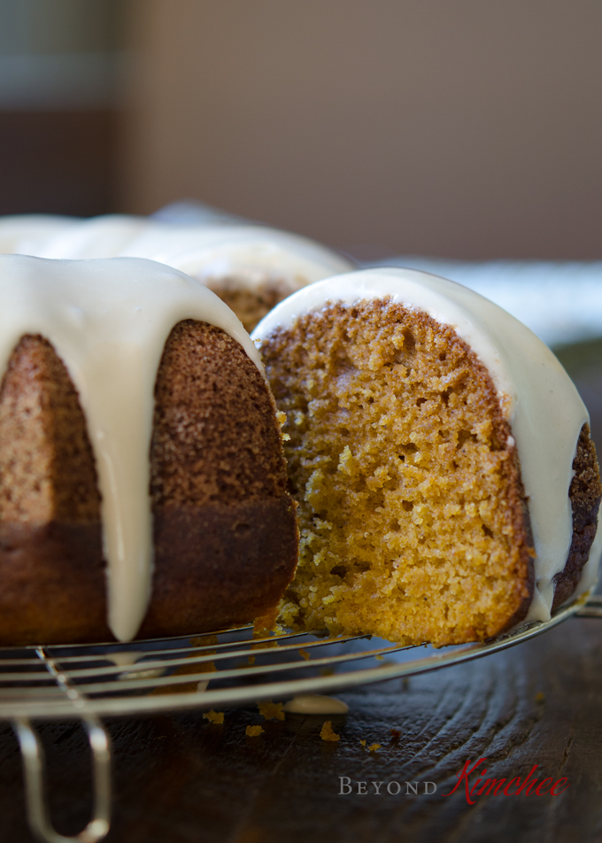 A slice of glazed pumpkin bundt cake is showing a moist tender crumb.