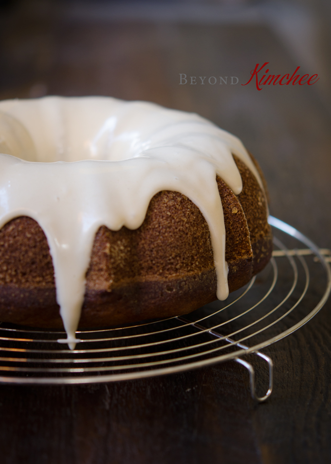 Cream cheese maple glaze is dripping down on a pumpkin bundt cake.