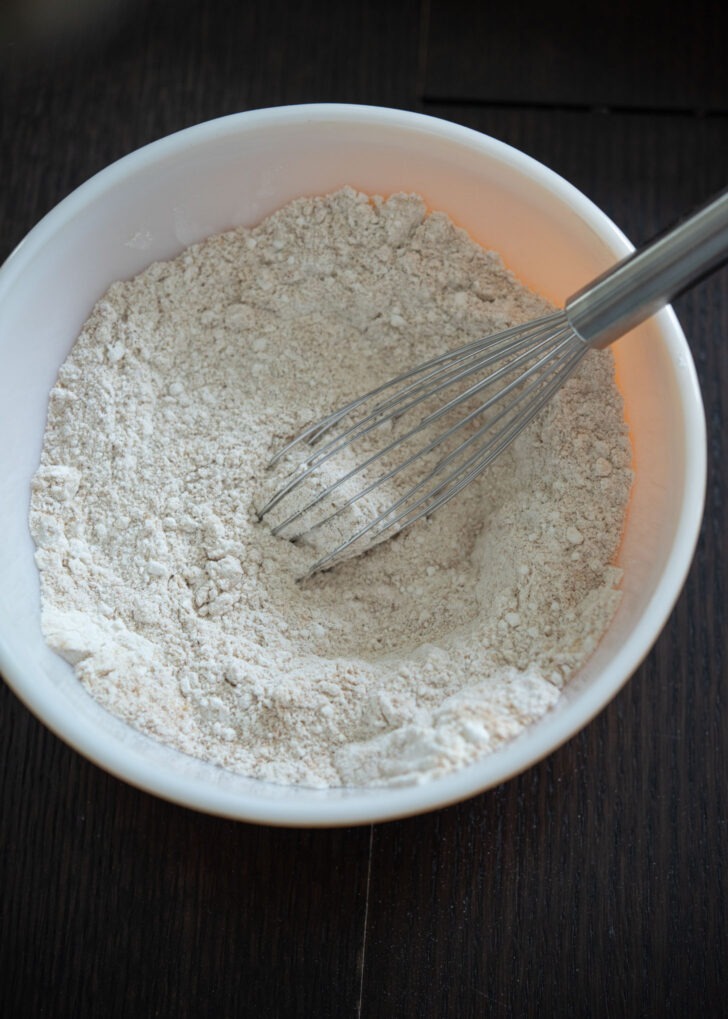 Yellow cake mix and graham cracker crumbs whisked together in a bowl.