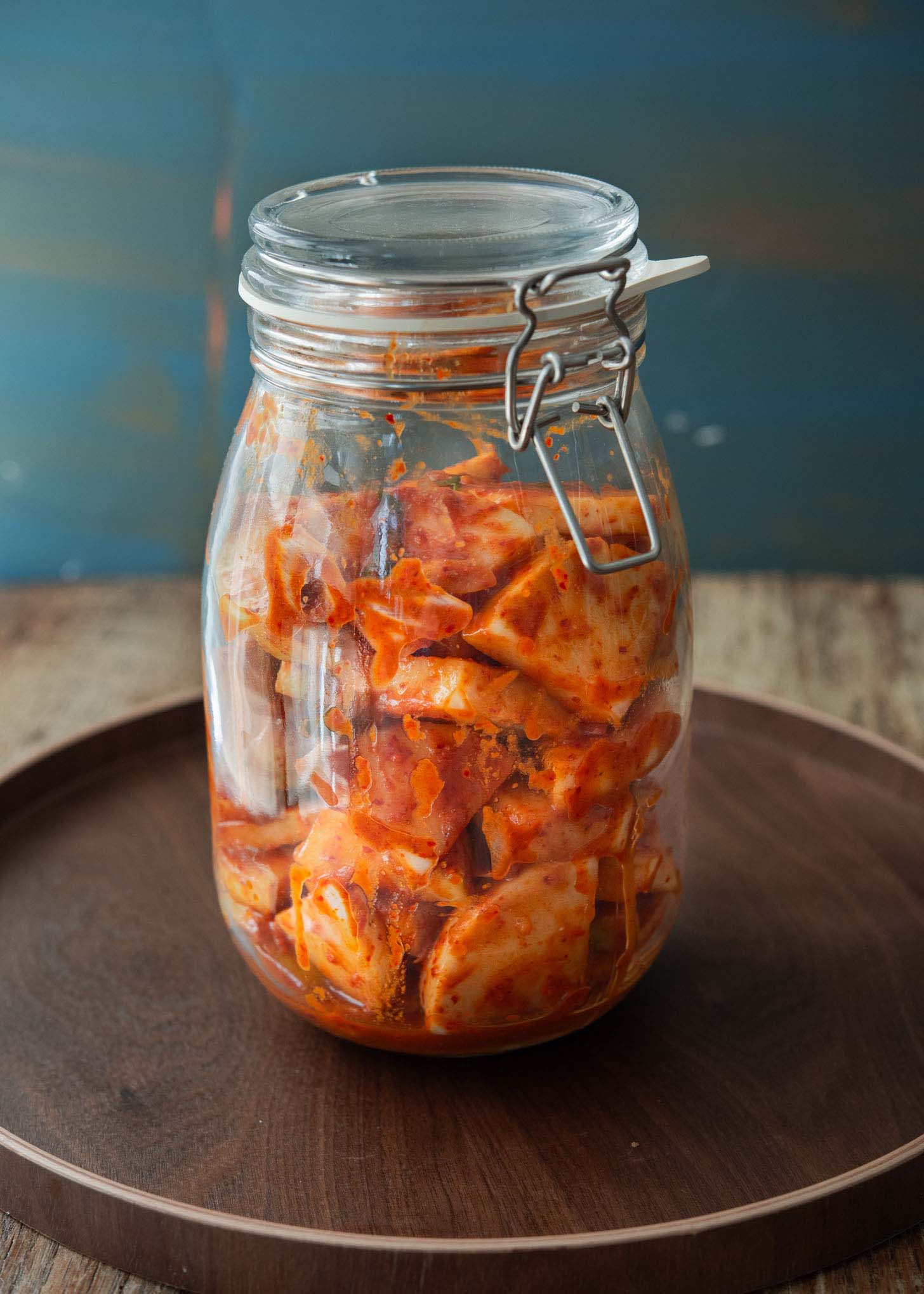 Radish kimchi fermenting in a glass jar.
