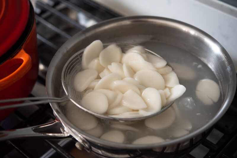 Boiling rice cake separately will reduce the heavy starch in the soup at the end.