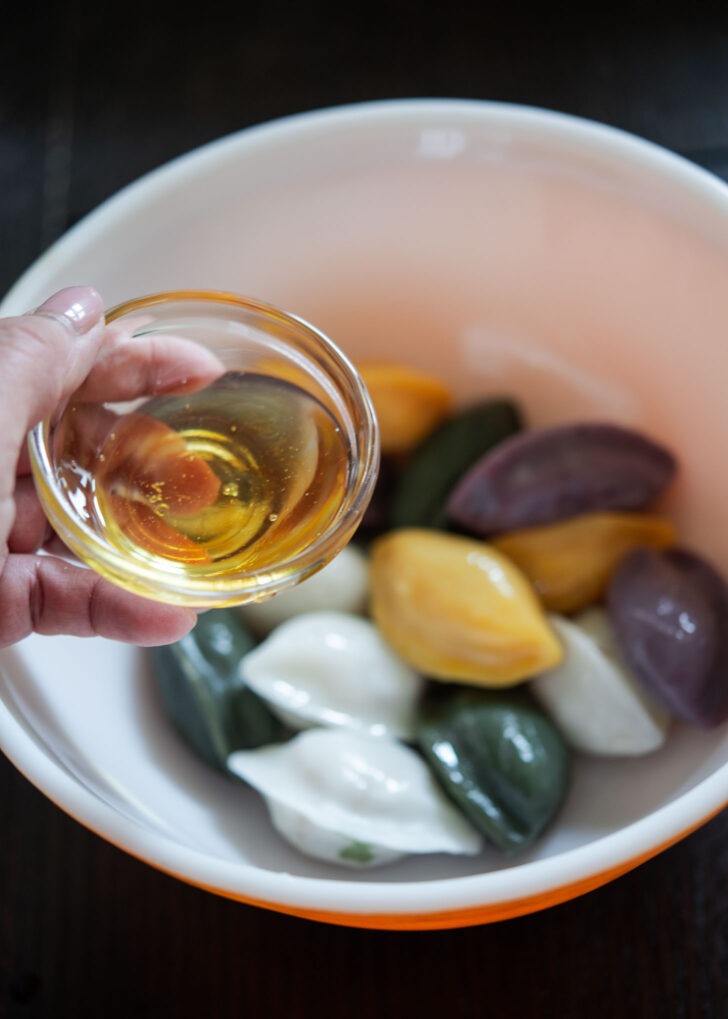 Oil is applied to steamed Korean half-moon rice cakes.