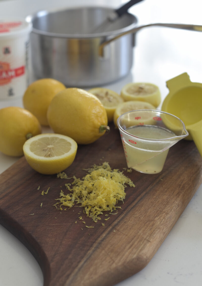 Fresh lemon is zested and squeezed to collect lemon juice.