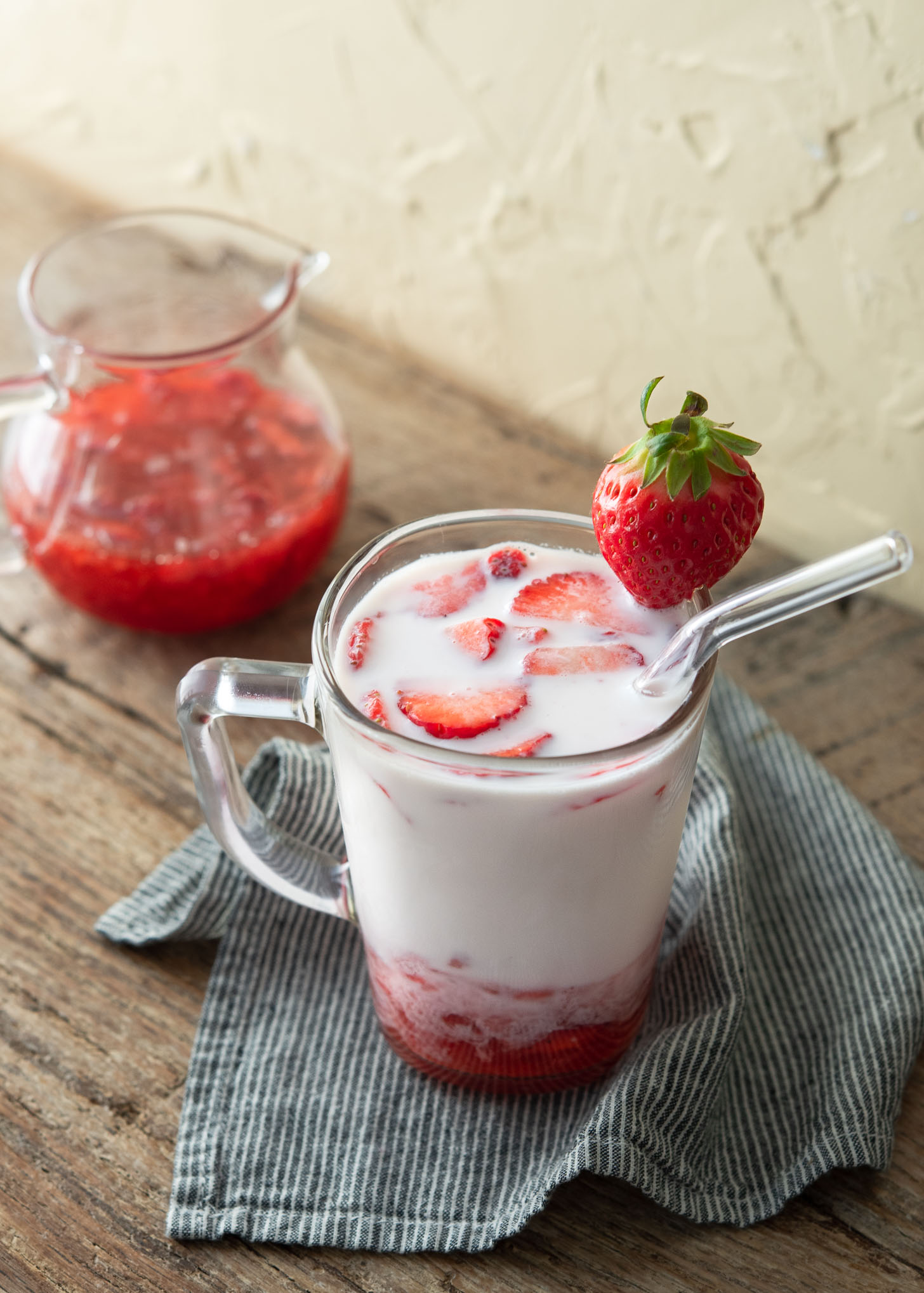 Korean strawberry milk presented in a glass cup garnished with fresh strawberries.