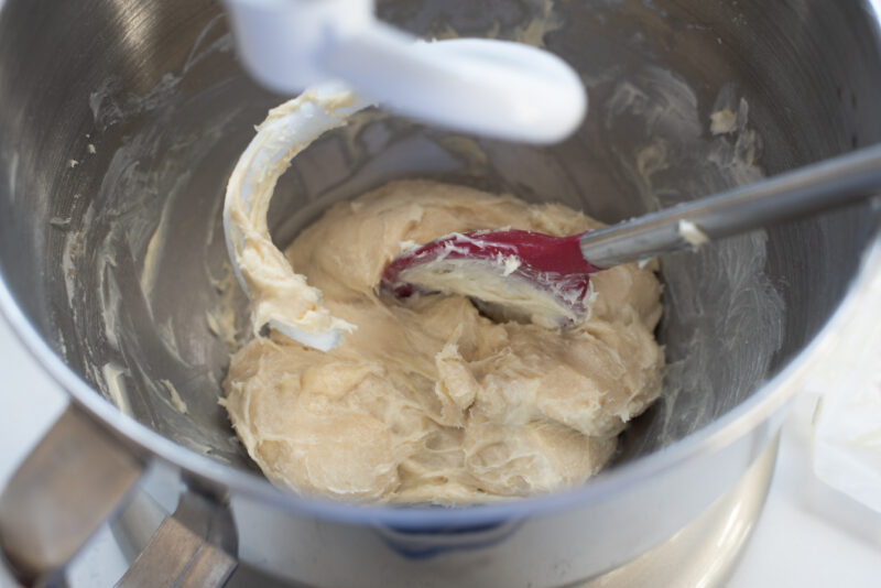 Brioche dough show a sticky texture after butter is added and mixed in with a spoon.