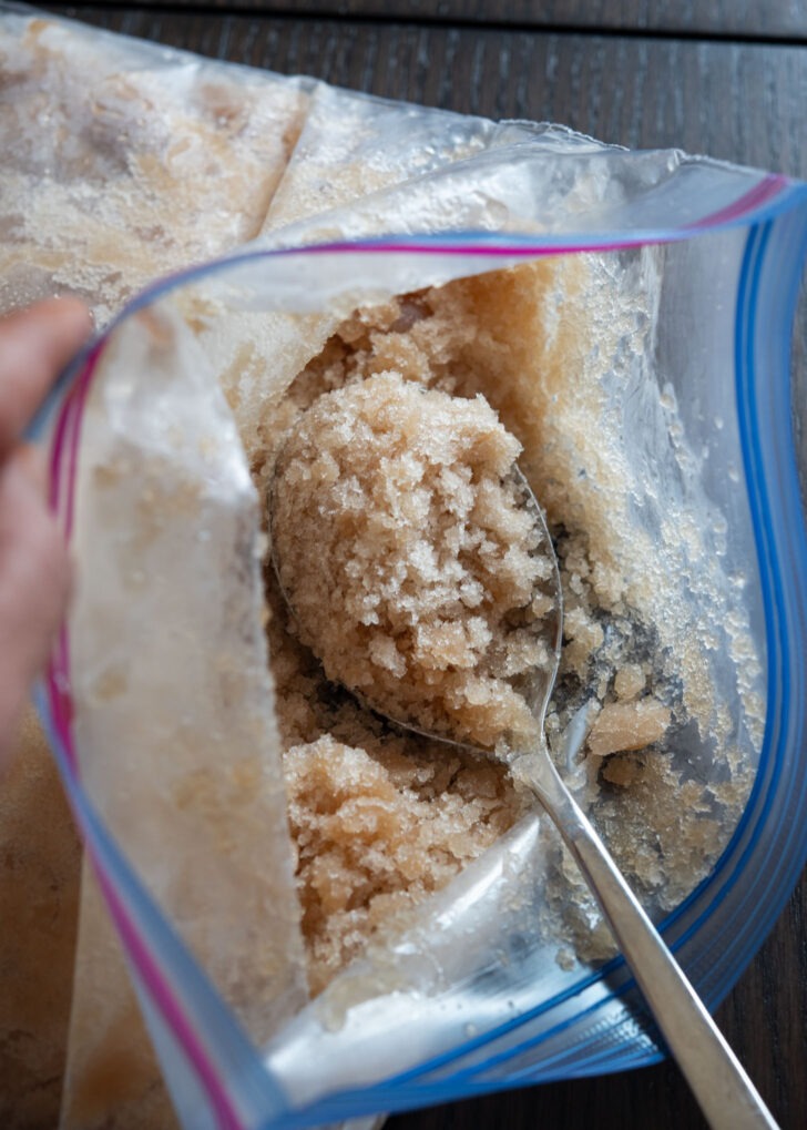 A spoon is scooping up a portion of crushed cinnamon ice.