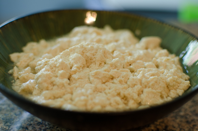 Soft tofu is crumbled in a bowl.