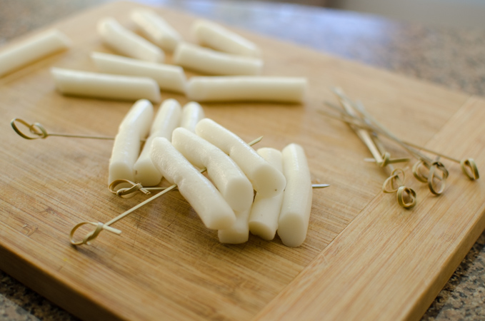 Three short rice cakes are skewered together on to each mini bamboo skewer.
