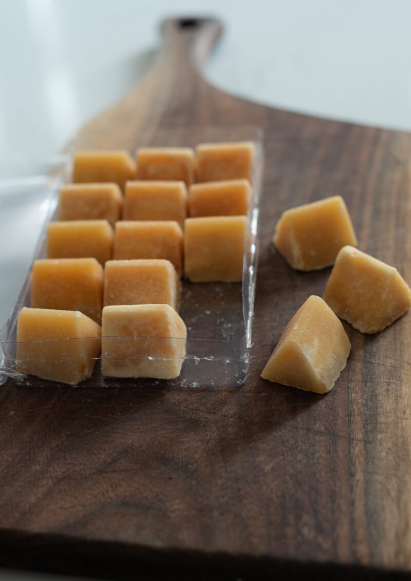 A package of palm sugar cubes placed on a wooden board.